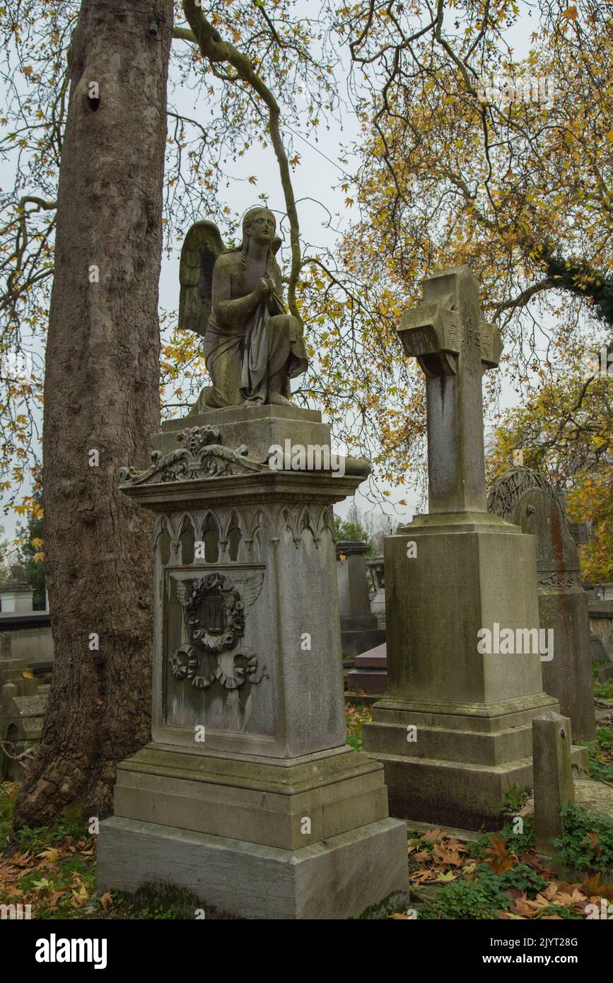 Sculture in pietra vittoriane in una giornata grigia d'inverno nel cimitero di Kensal Green a Londra, Regno Unito Foto Stock