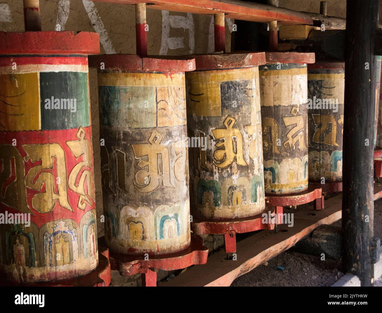 Ruote di preghiera buddhiste scolpite da legno di legno e utilizzate per praticare il buddhismo tibetano in Cina, in un tempio locale in un villaggio al di fuori della città antica di Songpan, nella provincia settentrionale del Sichuan, in Cina. PRC. (126) Foto Stock