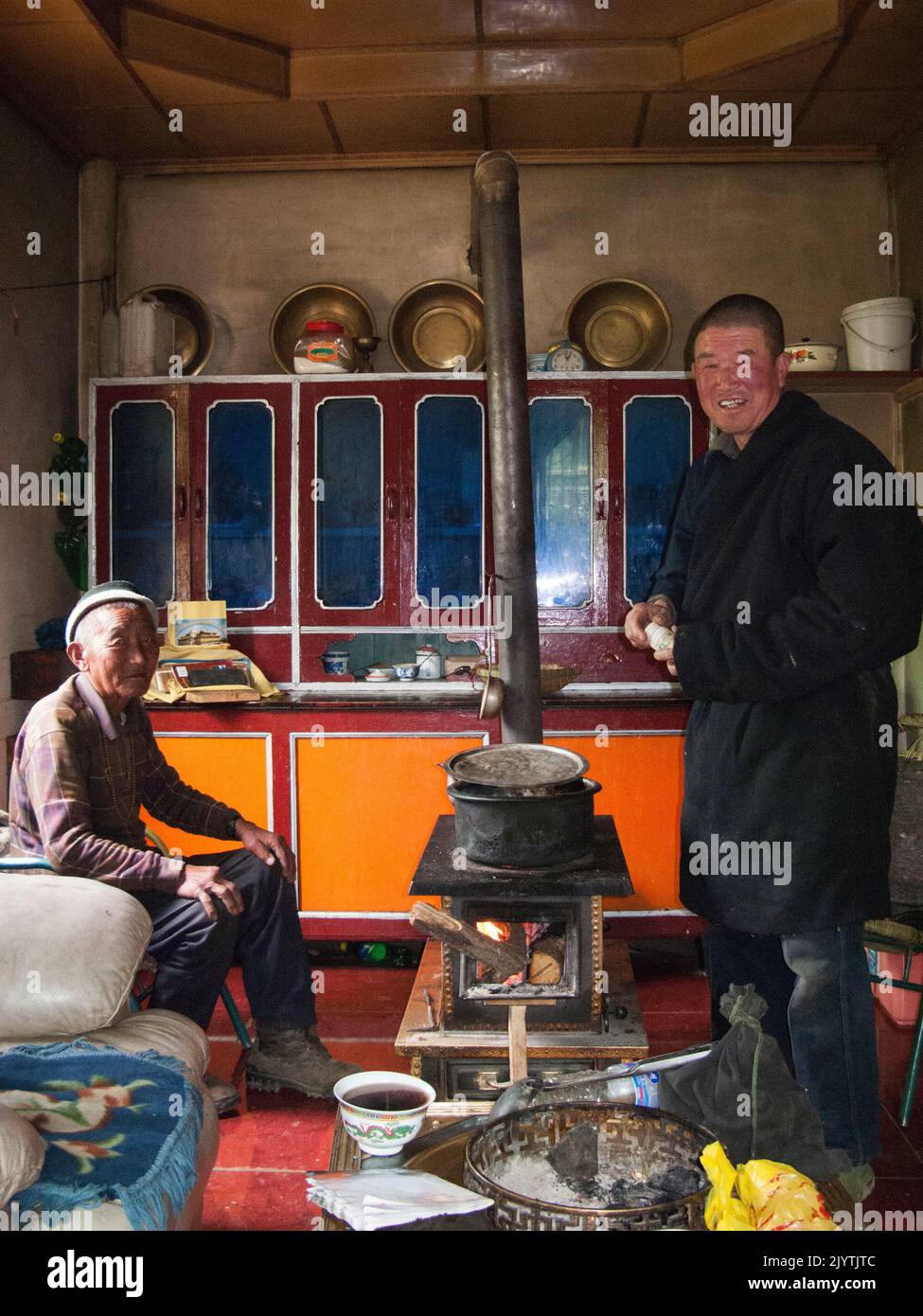 Gli uomini di una famiglia etnica tibetana preparano cibo, cucina e mangiare noodle pasto preparato per una visita turistica occidentale in un piccolo villaggio fuori Songpan antica città nella provincia settentrionale di Sichuan, Cina. PRC. (126) Foto Stock