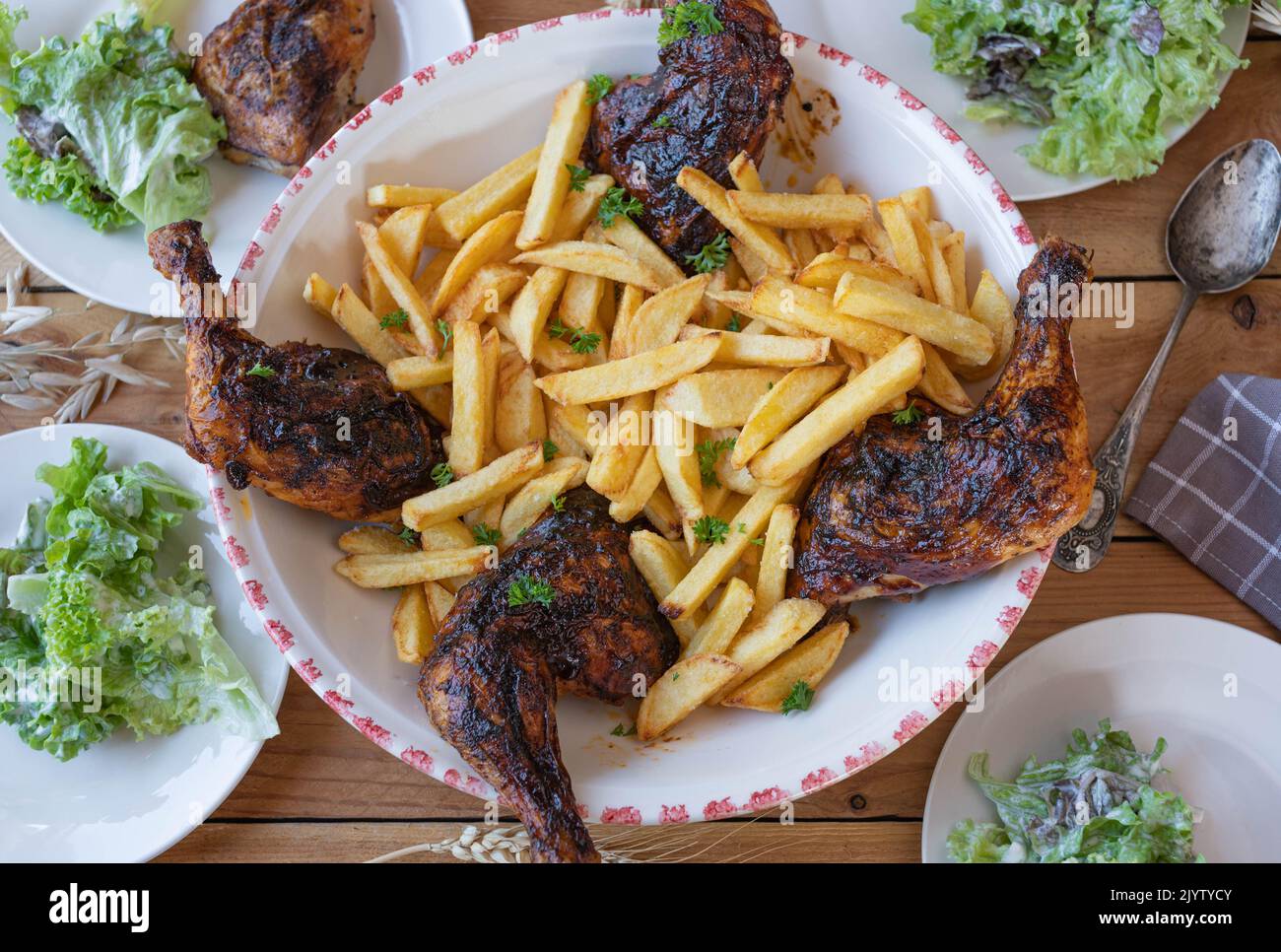 Cosce di pollo al barbecue con patatine fritte fatte in casa. Delizioso pasto per famiglie Foto Stock