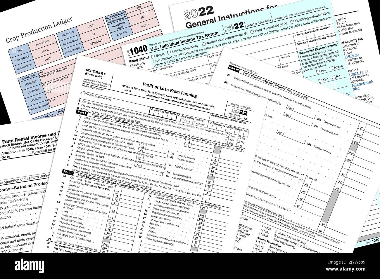 2022 IRS 1040 e moduli fiscali per aziende agricole con una pagina simulata di produzione del raccolto su un desktop nero. Foto Stock