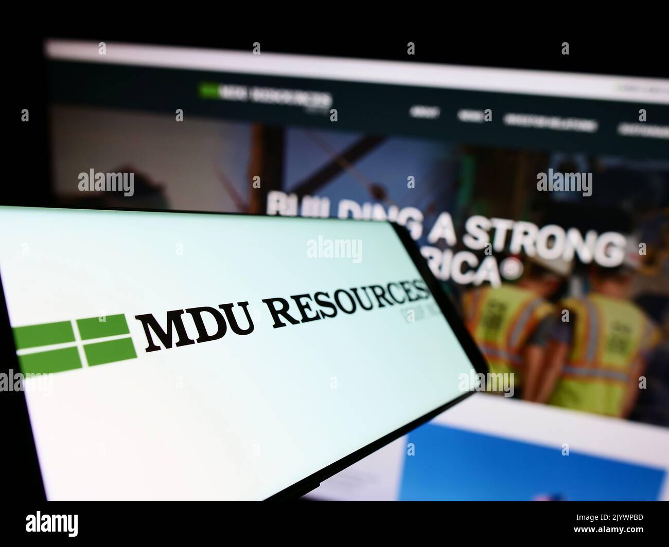 Telefono cellulare con il logo della società americana MDU Resources Group Inc. Sullo schermo di fronte al sito web. Messa a fuoco al centro a sinistra del display del telefono. Foto Stock