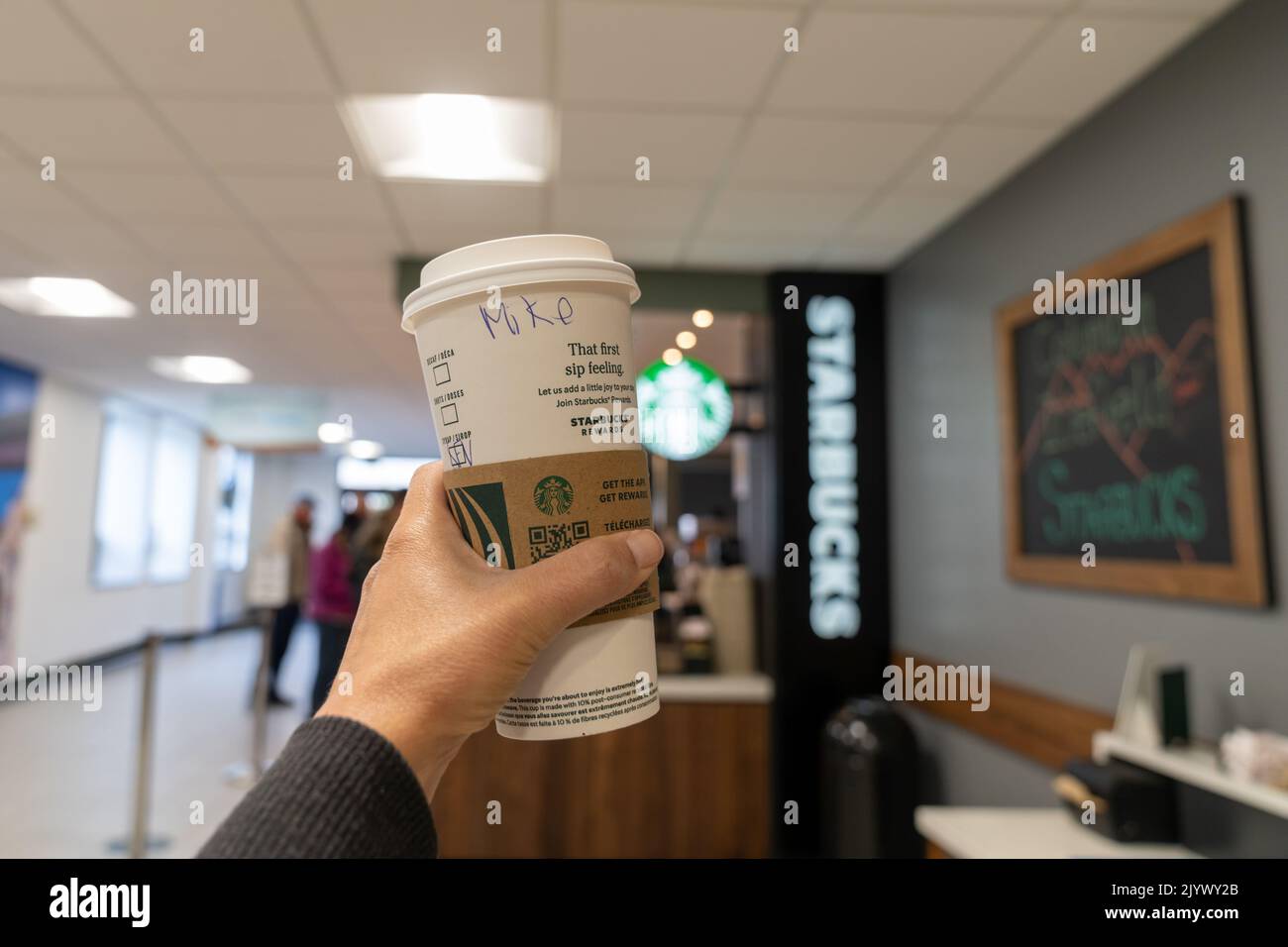 Alberta, Canada - 14 luglio 2022: La mano tiene in mano un caffè acquistato presso il Columbia Icefield Starbucks all'interno del centro visitatori delle Montagne Rocciose canadesi Foto Stock