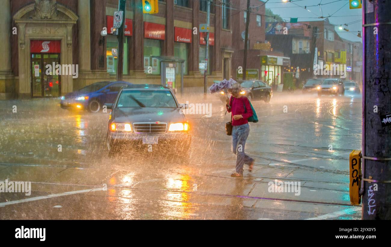 Persone sotto la pioggia nella città di Toronto. Tempesta nel pomeriggio Foto Stock