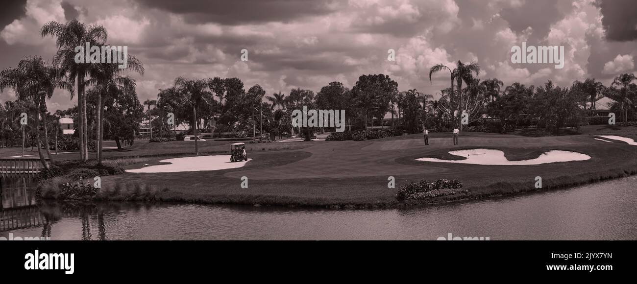 Campo da golf con due uomini al tee. Fotografia panoramica, grandangolo con luce al mattino presto. Non c'è folla, tranquillo e sereno. Foto Stock