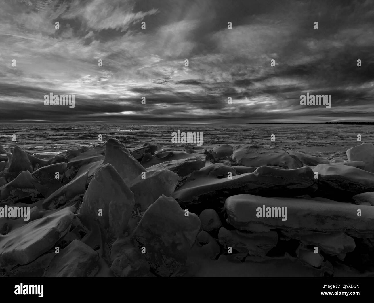 Il sole tramonta sulle acque di Green Bay (del lago Michigan) dalla riva del Peninsula state Park con le zacchette di ghiaccio in primo piano, Door County, Wisconsin Foto Stock