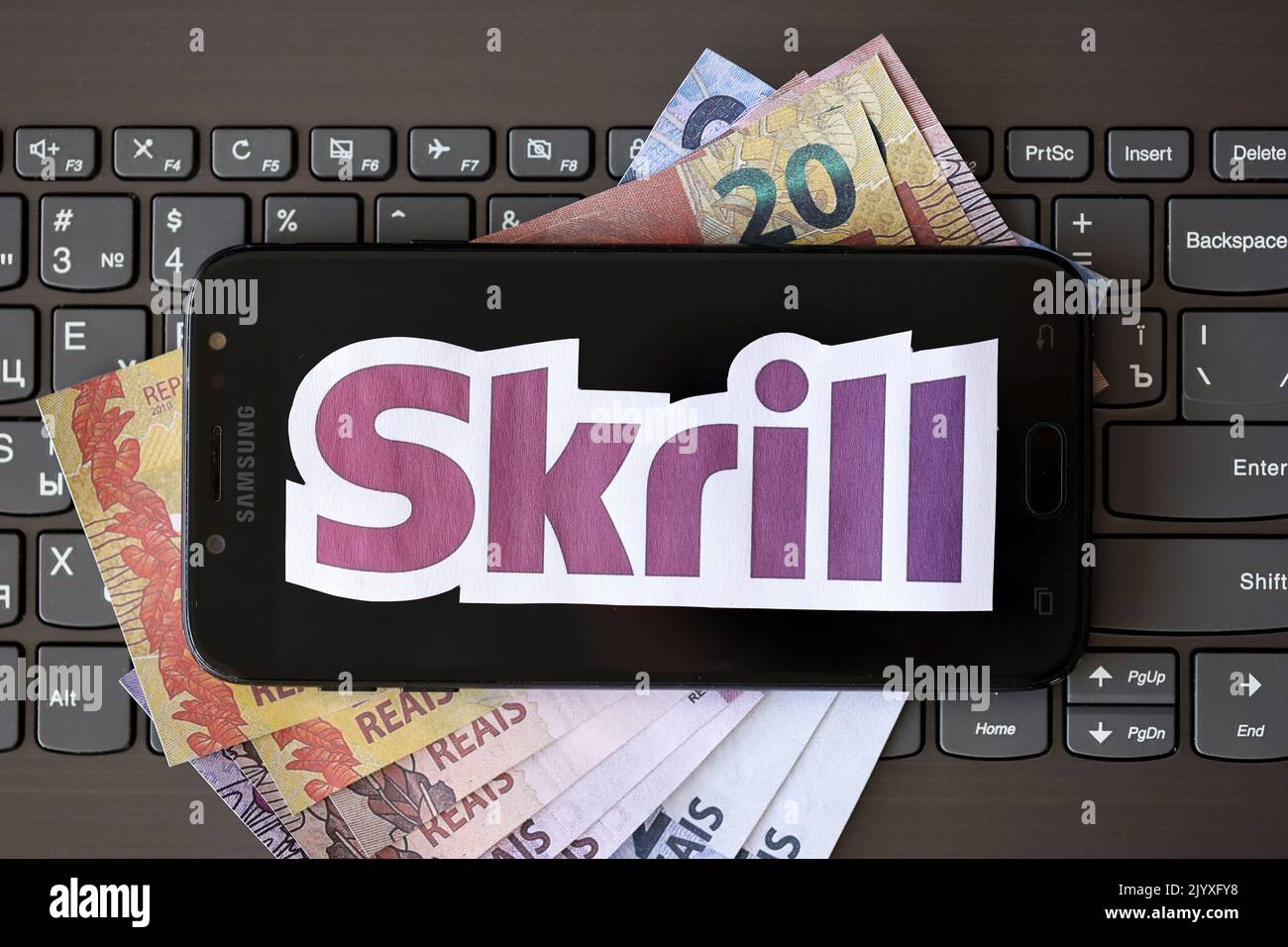 TERNOPIL, UCRAINA - 6 SETTEMBRE 2022 il logotipo di carta Skrill si trova sulla tastiera nera del notebook con le fatture brasiliane. Payoneer è americano finanziario s Foto Stock