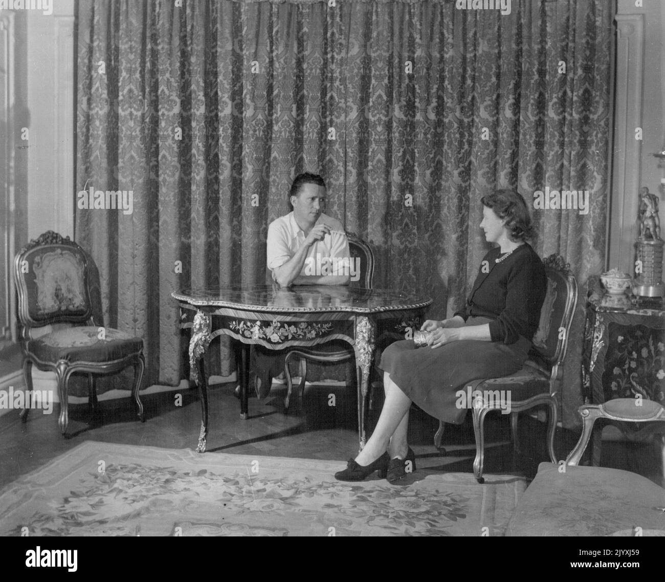 Sprod interrompe la signora Curley nel bel mezzo della pulizia di una copia dorata in argento di un antico greco ***** Tazza la camera ha mobili Luigi XV, tappeto Quburrow orologio regency. Nella sua casa Hampstead, piena di preziosi oggetti d'antiquariato, cerca di insegnare alla sua governante, la signora Curley, nuovi trucchi per la pulizia, ma senza alcun successo. Ottobre 23, 1953. (Foto di Ross Freeman/Fairfax Media). Foto Stock