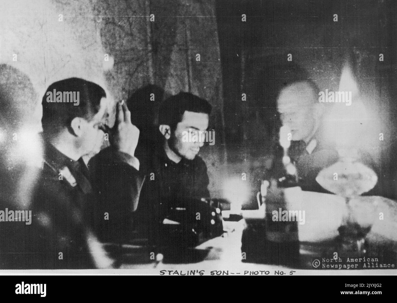 L'interrogatorio del figlio di Stalin prosegue nella notte successiva alla sua cattura, alla luce di una lampada ad olio vicino al quartier generale della Quarta Esercito tedesca sotto il maresciallo di campo Gunther von Kluge. Da sinistra a destra ci sono Captain Renschle, Lieut. Jacob Djugashvili (conosciuto come 'Yashaa') e l'interprete dell'Esercito tedesco, un uomo di nome Idol. Marzo 17, 1951. Foto Stock