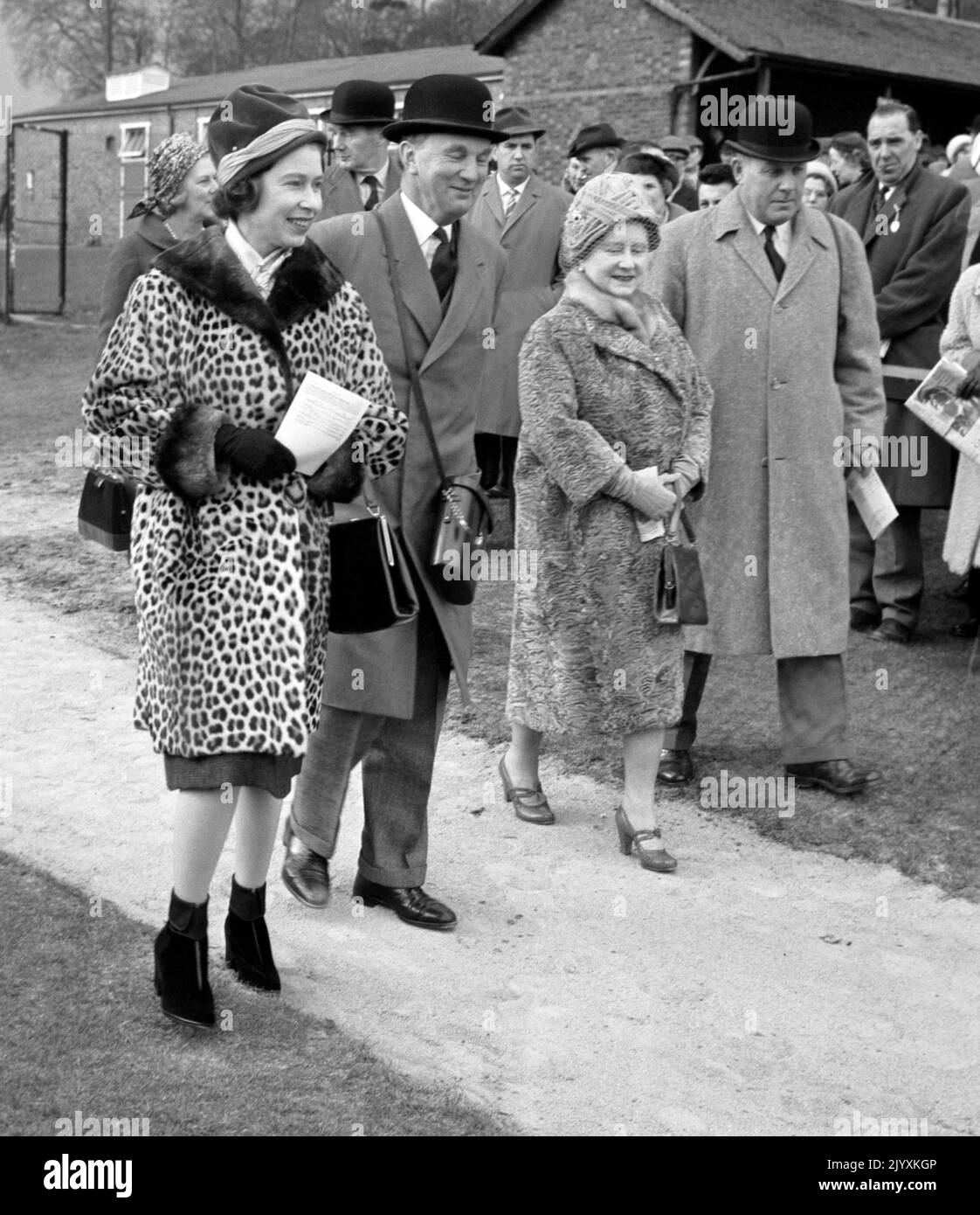 File foto datata 23/3/1962 della Regina Elisabetta II indossando un caldo cappotto in pelle di leopardo in una giornata di marzo molto fredda alla riunione di gara di Sandown Park, accompagnata dalla Regina Elisabetta, la Regina Madre. Elisabetta II era famosa per il suo amore per i colori a blocchi e cappelli coordinati e la sua moda divenne una parte leggendaria del suo ruolo di monarca. La regina una volta è stata descritta come "medicazione di potere in extremis" per l'uso di sfumature vibranti per farsi notare dalla folla, mentre i suoi cappelli le hanno permesso di essere facilmente avvistata, ma erano abbastanza piccole in modo che il suo volto era visibile. Data di emissione: Giovedì 8 settembre 2022. Foto Stock