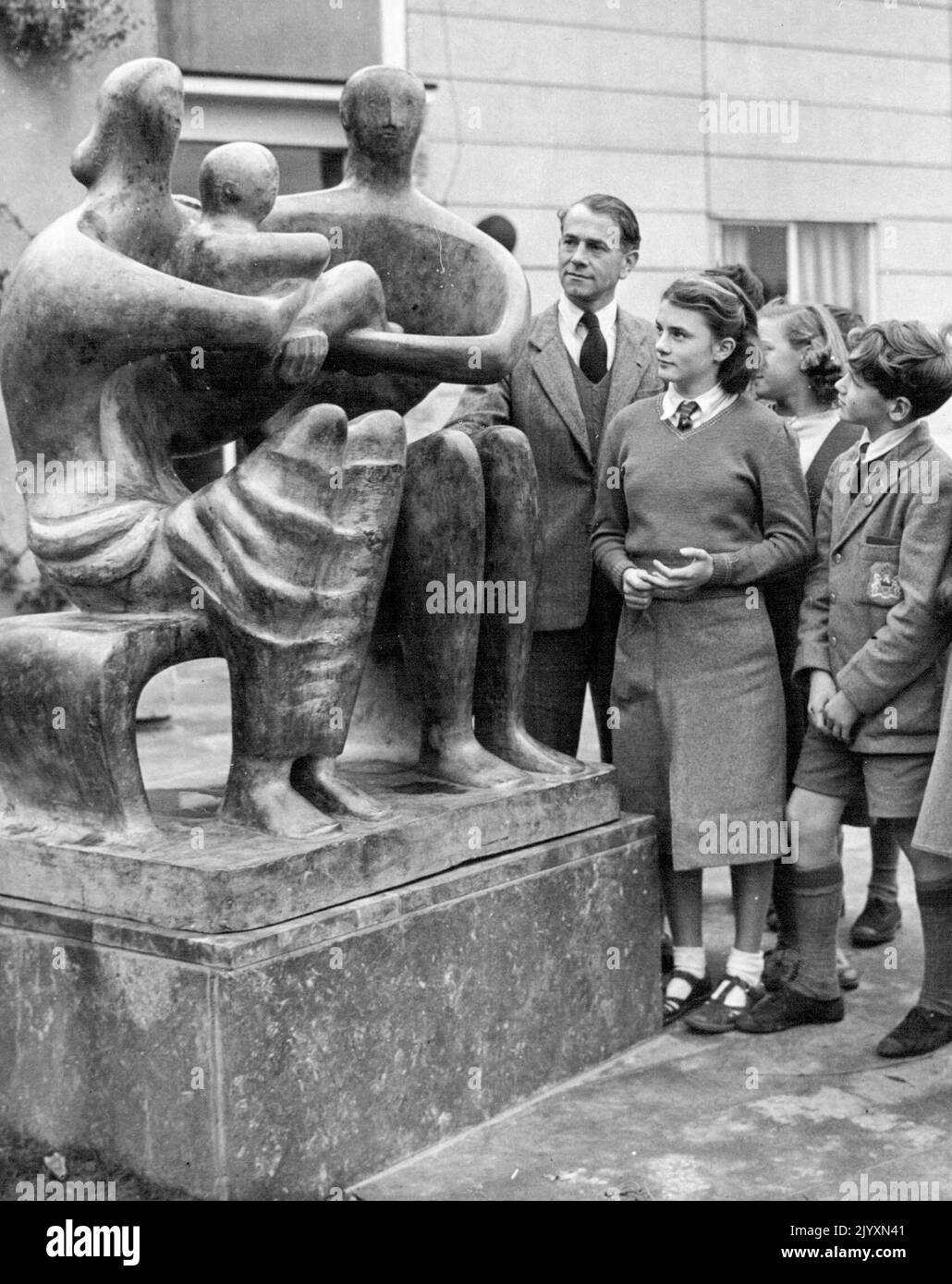 ***** Direttore Sig. P.J. Osmund e alcuni degli allievi della scuola secondaria di Barclay, Stevenage, Hertfordshire, che osservano una statua del £800 di un uomo, donna e bambino a grandezza naturale, in bronzo, che arrivò durante la notte nei terreni della scuola. La maggior parte della scuola, compresi molti dei governatori, non piace la statua. Dice Brian Woods di 12 anni 'e' orribile - l'uomo e la donna non hanno go4t stomaci, e le loro teste sono solo sciocchite. La scultura, di Henry Moore, è stata commissionata, con l'approvazione del Comitato per l'Educazione, dal Sig. Yorke, l'architetto che ha progettato la scuola. Novembre 3, 1 Foto Stock
