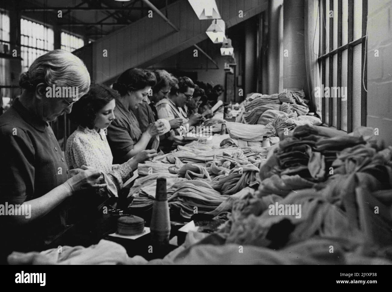 Nylon sulla strada -- Una scena occupata nella fabbrica di Nottingham di I. & R. Morley. Questi lavoratori fanno l'ispezione finale dei nylon finiti prima che si incontrino con il processo di tintura, e sottoponono le calze ad un processo scientifico di sgrossatura conosciuto come "cratching". Le calze di nylon, tanto attese dalle donne britanniche, saranno nei negozi entro Natale. Le industrie della calzetteria, che impiegano 60.000 lavoratori, sono impegnate in un'azione completa per portare sul mercato i nylon in quantità e le forniture inizieranno ad apparire dopo dicembre 1st. Novembre 13, 1946. (Foto di Reuterphoto) Foto Stock