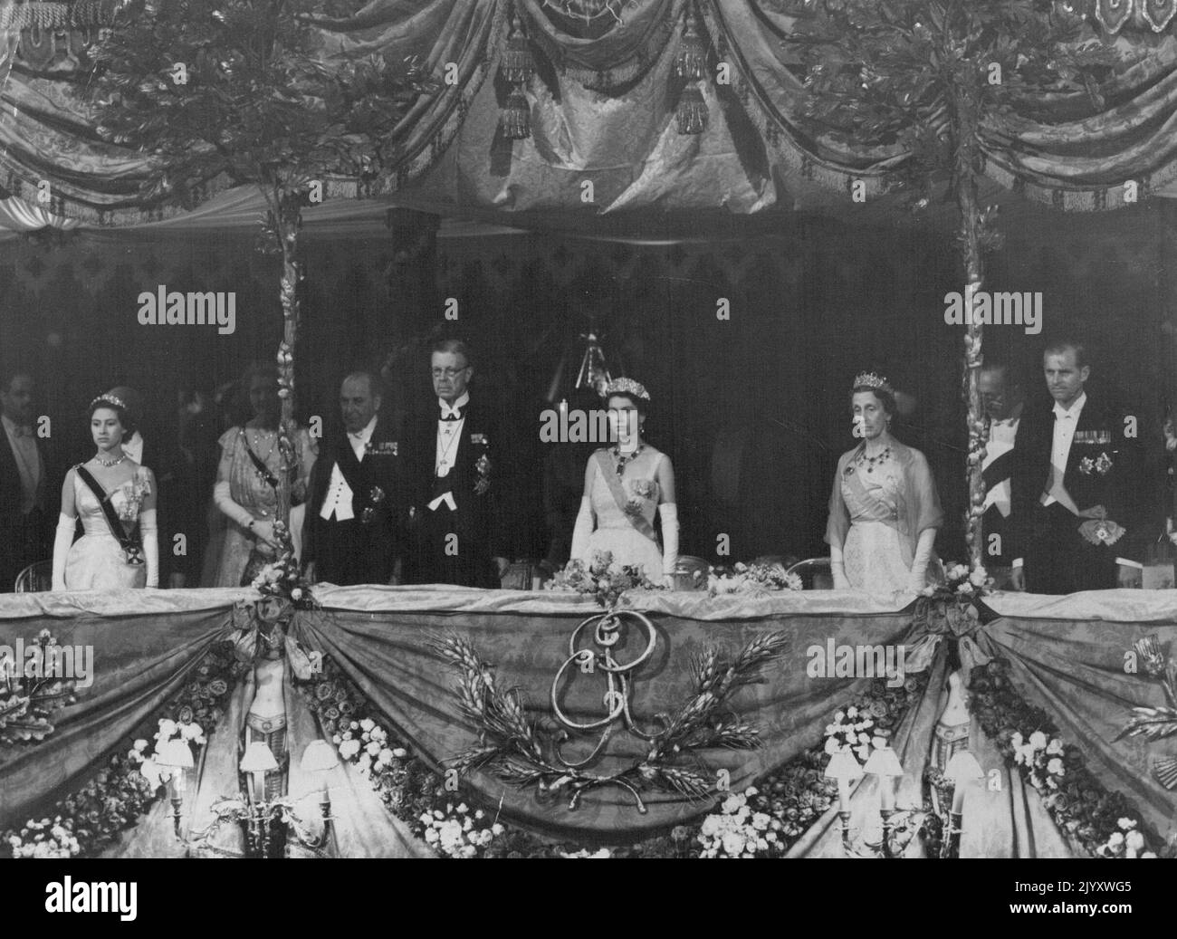 Gioielli e ordini ***** E colora la scena brillante nella scatola reale mentre la regina ed i suoi ospiti si levano in piedi durante il gioco della nazionale ***** Prima dello spettacolo di Gala, regalate al Royal Opera House Covent Grader, Londra, questa sera (mercoledì) in onore del re Gustav Adolf e della regina Luisa di Svezia, ora in visita di Stato in Gran Bretagna. Da sinistra a destra Principessa Margaret: Lord Waverley: Re ***** Adolf: La regina: La regina Luisa: Le marchee di Salisbury: E il duca di Edimburgo. Giugno 30, 1954. (Foto di Reuterphoto) Foto Stock