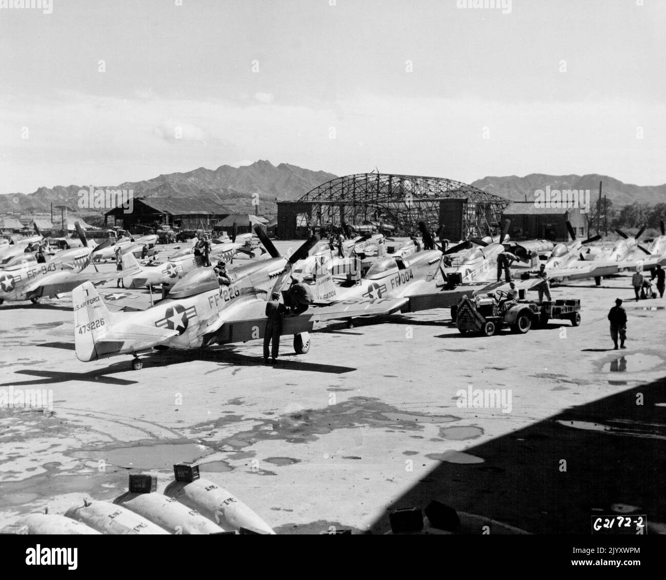 Re - operazioni preparanti iniziano -- quando le forze aeree statunitensi F - 51 Mustangs del veterano 18th Fighter Bomber Wing ritorno da uno sciopero di combattimento su obiettivi comunisti in Corea del Nord, si formano nella fila 'follow-the-leader' come mostrato sopra per l'efficienza nel ricaricamento di munizioni e operazioni di riarmo. Il carrello di rifornimento è occupato nella parte anteriore, poiché gli equipaggi caricano. Munizioni di calibro 50 nei compartimenti alari del Mustang a destra. Presto i rimorchi che trasportano razzi e bombe si diranno attraverso le linee dei combattenti - bombardieri. Caricando i missili ad alta velocità appena passano ogni aereo. I serbatoi Napalm sono Foto Stock