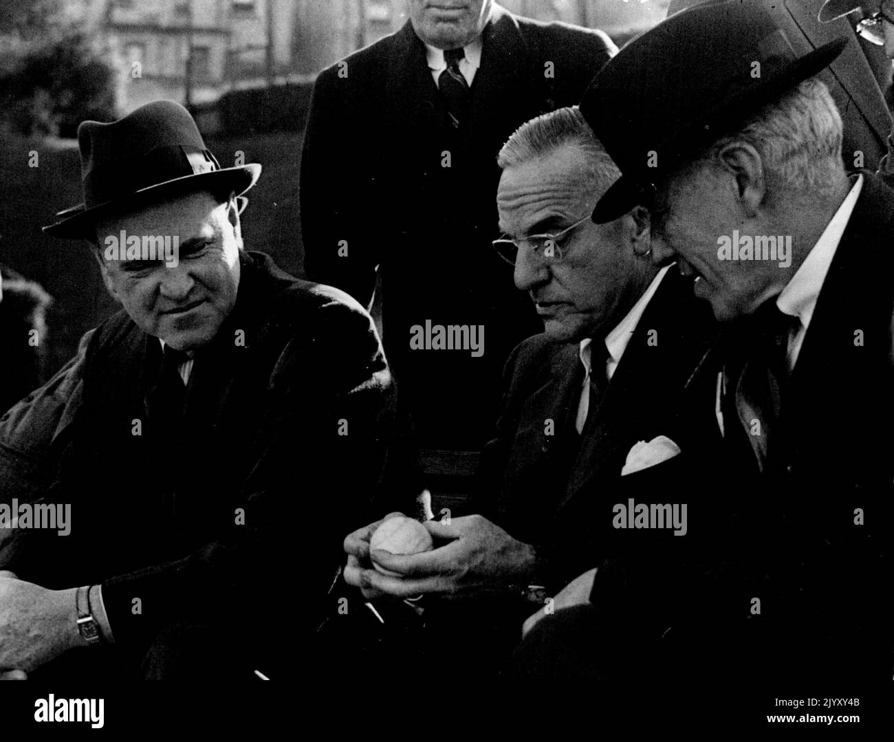 I capitani della Coppa Davis non giocanti Gerald Patterson (Australia) se ne andarono, e Walter Pate (Stati Uniti), al centro, discutono della marca della palla da tennis da utilizzare nel Challenge Round con IL presidente ALTA, Sir Norman Brookes. Novembre 24, 1946. Foto Stock