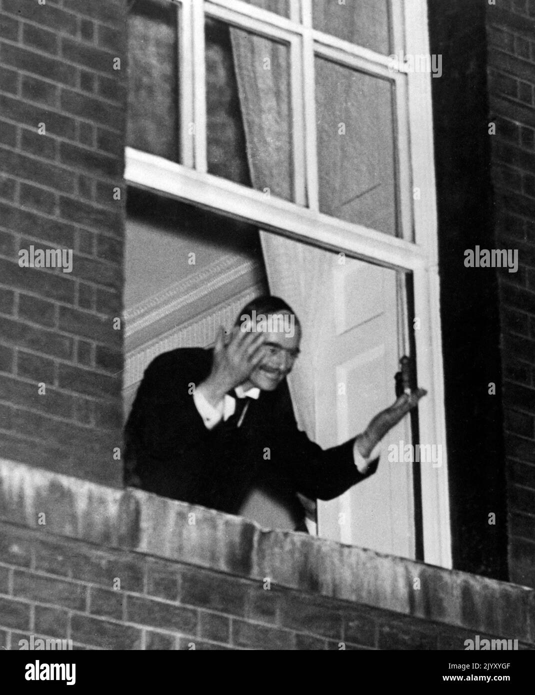 1938: Foto del file datata settembre 1938 del primo ministro Neville Chamberlain che sventolava alla folla dalla finestra del n° 10 dopo la firma dell'accordo di Monaco. Data di emissione: Giovedì 8 settembre 2022. Foto Stock