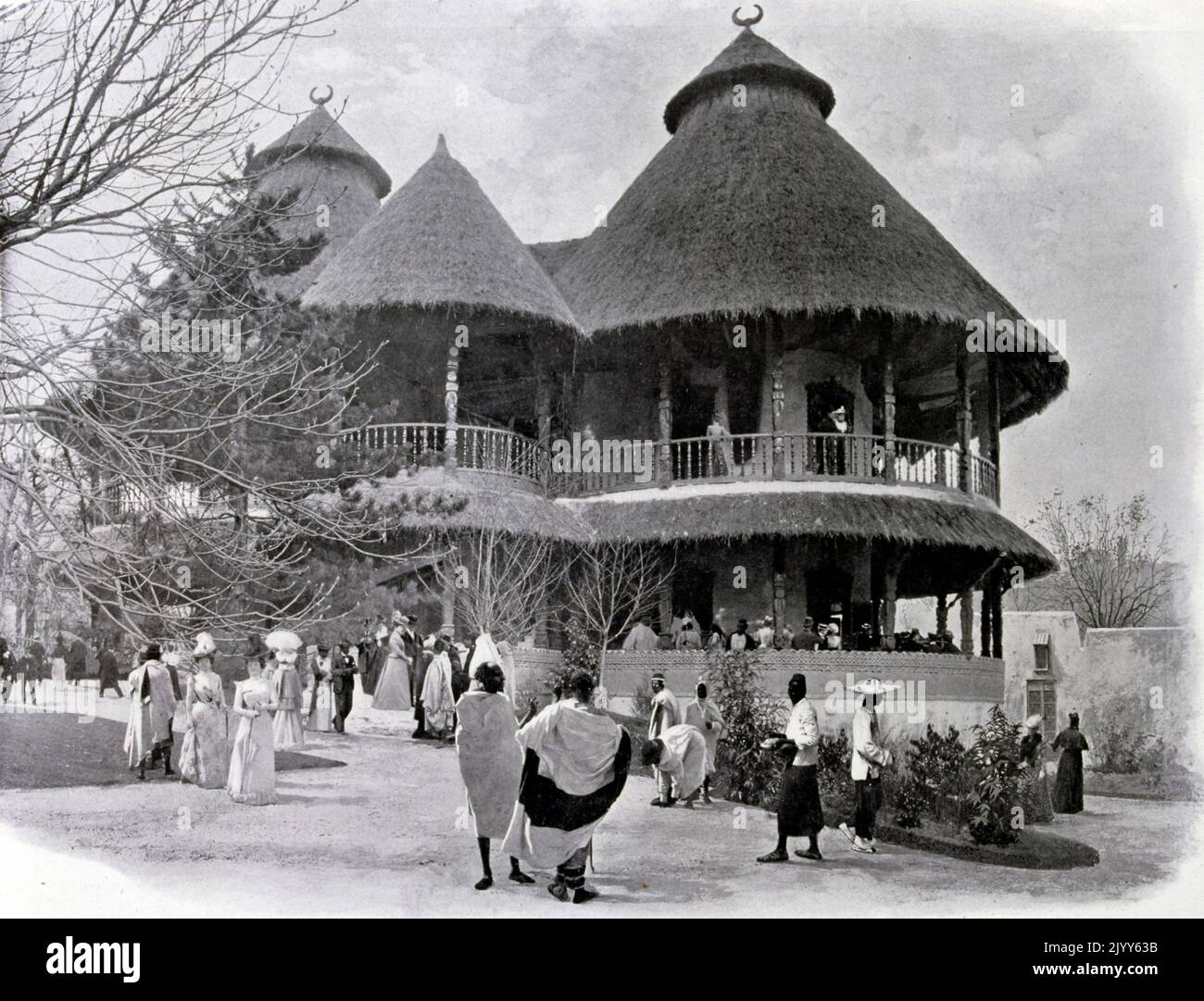 Esposizione Universelle (Fiera Mondiale) Parigi, 1900; Fotografia in bianco e nero della Guinea Francese Mostra che mostra un padiglione con due case indigene con rilievo decorativo. Foto Stock