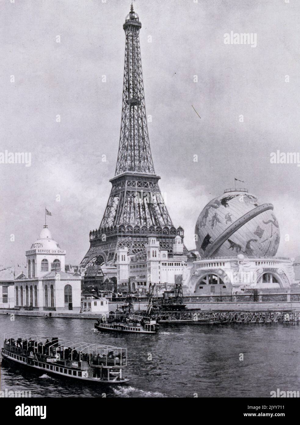 Esposizione Universelle (Fiera Mondiale) Parigi, 1900; fotografia in bianco e nero del globo celeste accanto alla Torre Eiffel vista dal fiume sulla Senna. Foto Stock
