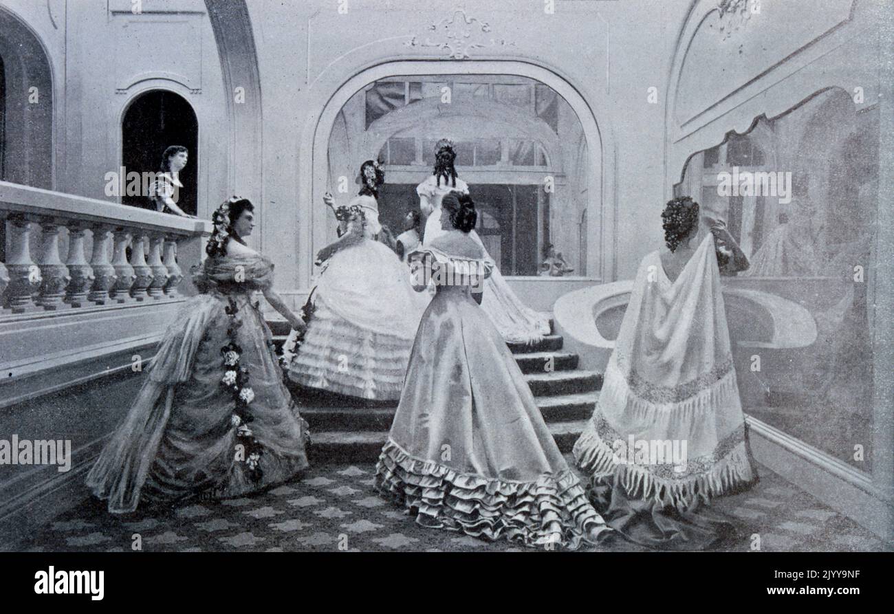 Foto in bianco e retro di donne in un grande corridoio modellando camici da sera. Tratto da una rivista di moda nel 1867. Foto Stock