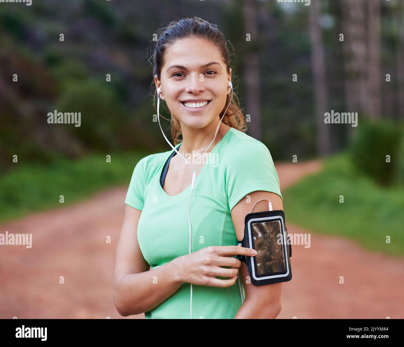 Preparati all'azione con la playlist giusta. Una giovane donna che ascolta musica mentre si è fuori corsa. Foto Stock