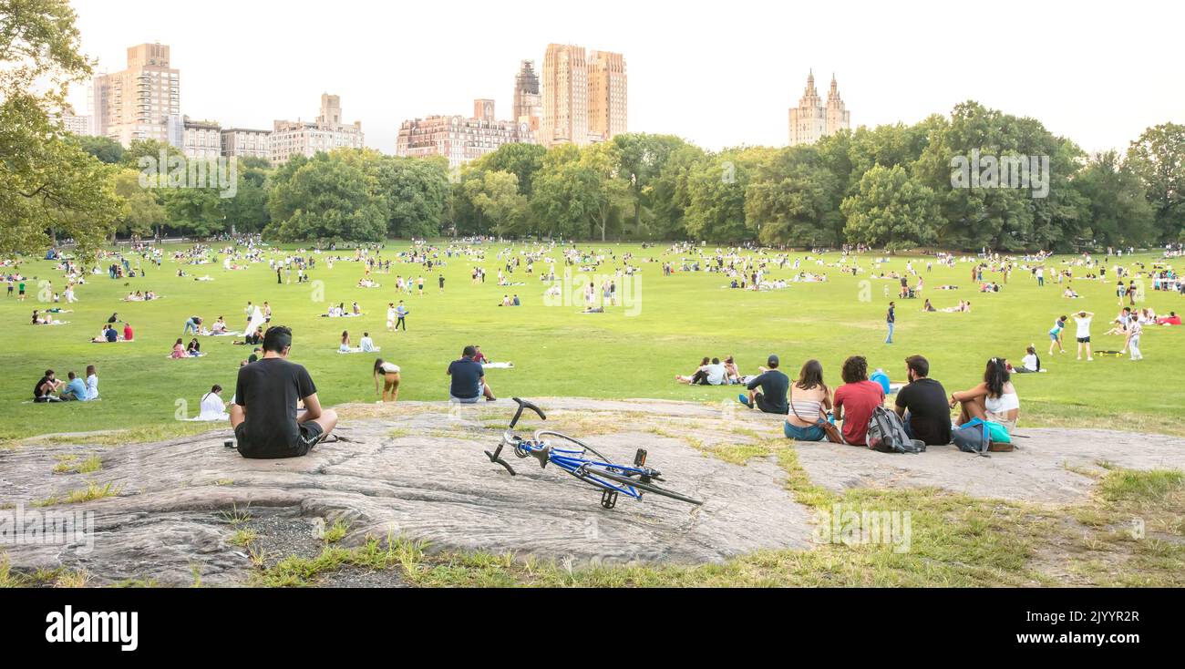 Persone a Central Park, Manhattan, New York City, USA alla fine di una giornata estiva Foto Stock