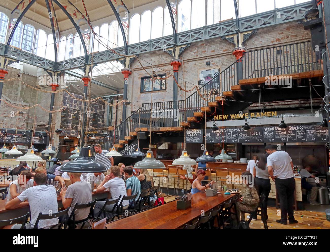 Mackie Mayor interni, tavoli da pranzo comuni, campo da cucina informale, Smithfield Market Hall, 1 Eagle St, Manchester M4 5BU Foto Stock