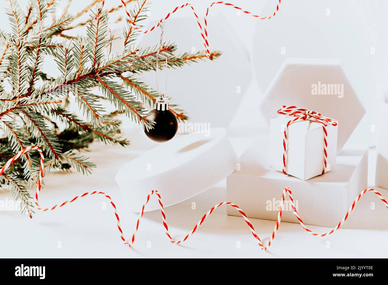 Sfondo di natale scandinavo minimalistico eco friendly in bianco. Rami di abete e podio bianco vuoto Foto Stock