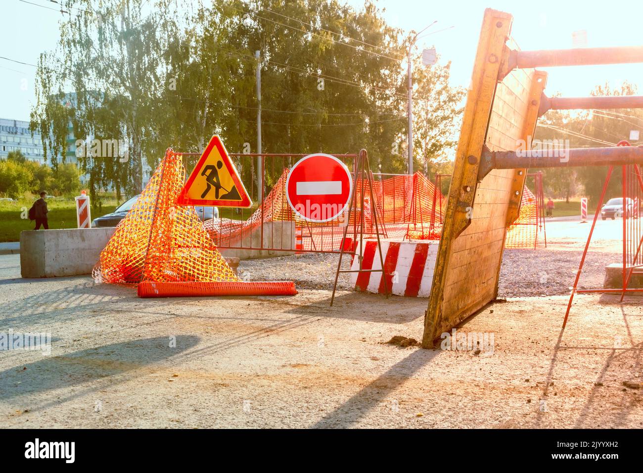 Chiusura parziale della carreggiata per i lavori di riparazione e restauro, la trincea rimossa si trova nelle vicinanze, la messa a fuoco selettiva e la retroilluminazione Foto Stock