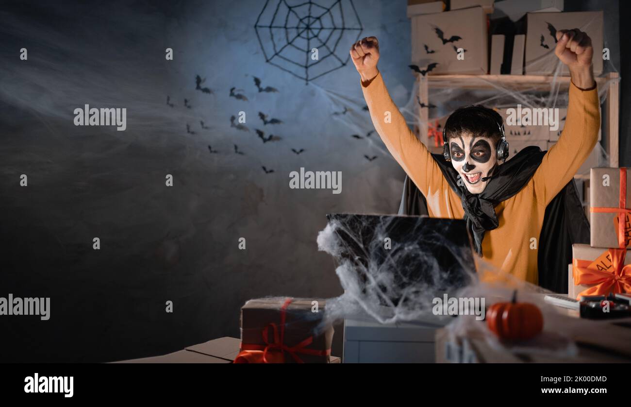 Arabo uomo business proprietario indossa cranio in argilla bianca, trucco professionale in casa ufficio. Emozioni di delizia. Ufficio decorato festivo. Vendita halloween Foto Stock