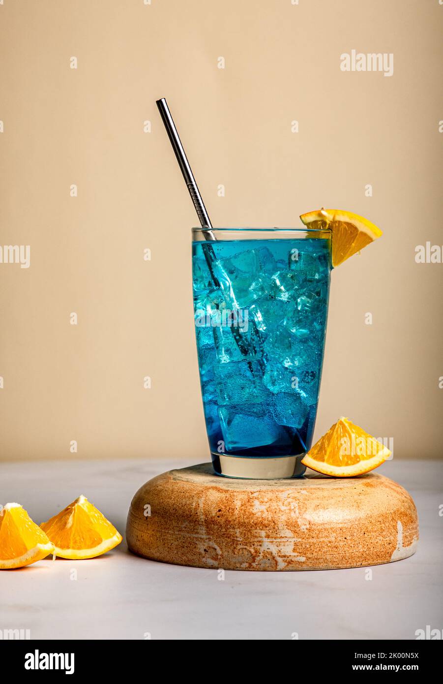 Blue Lagoon - una bevanda mocktail che è soda e di colore blu servita con cubetti di ghiaccio e fette di arancia fresca per dare una leggera tangenza. Foto Stock