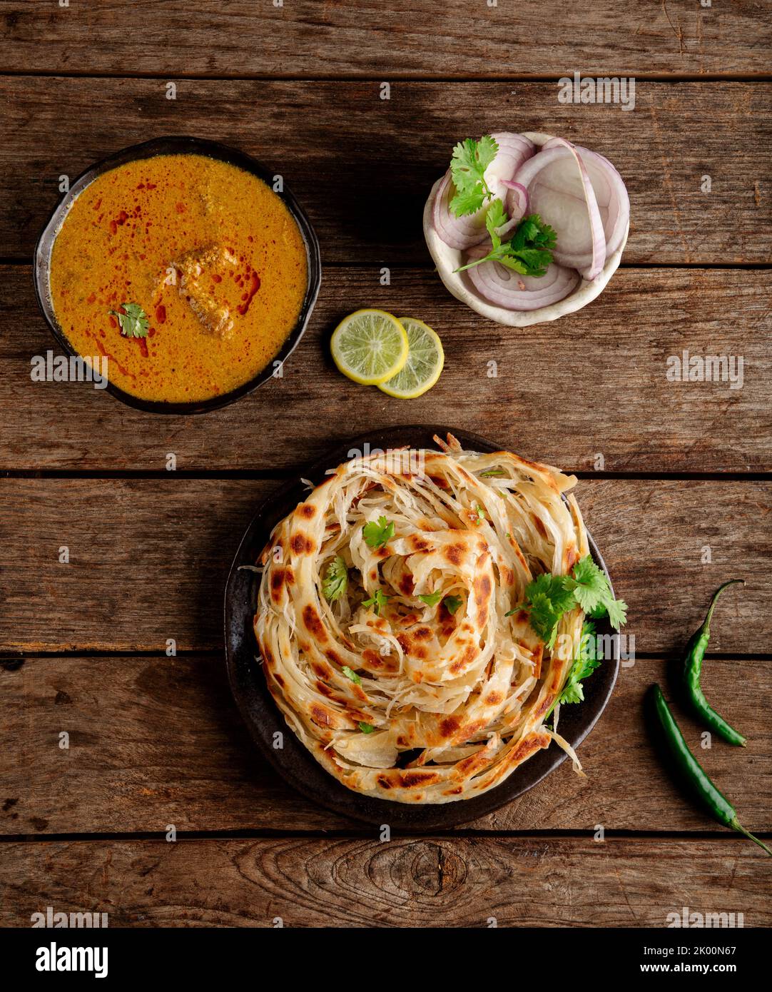 Parotta - un pane indiano a base di farina, cotto a scaglie e servito con autentica salsa di pollo dell'India meridionale (kurma) Foto Stock