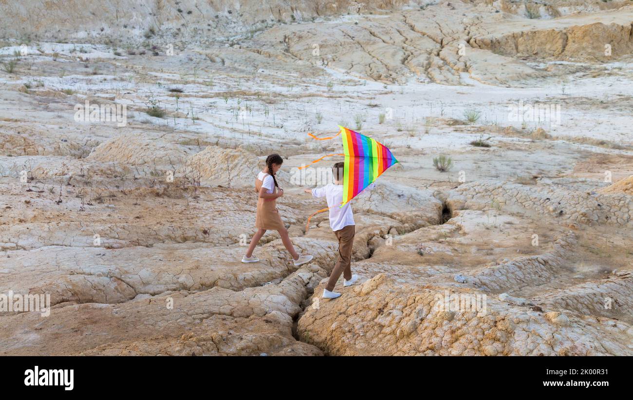 Bambini ragazzi e ragazze con un aquilone le mani salgono su un'alta montagna. Foto Stock