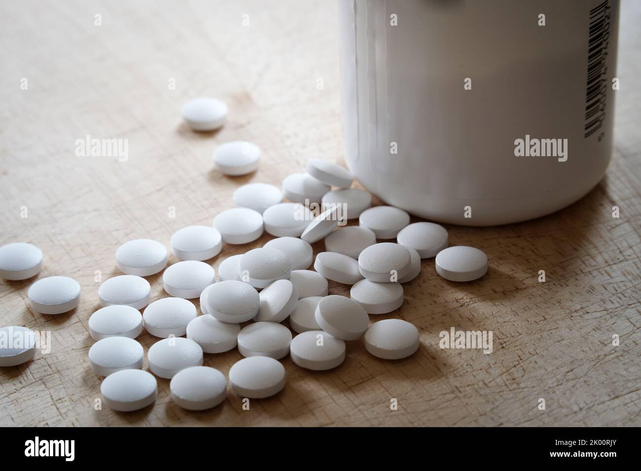 Medicina di plastica o vitamine bottiglia e capsule bianche pillole fuori, medicina e concetto di salute. Illustrazione di epidemie di oppioidi Foto Stock