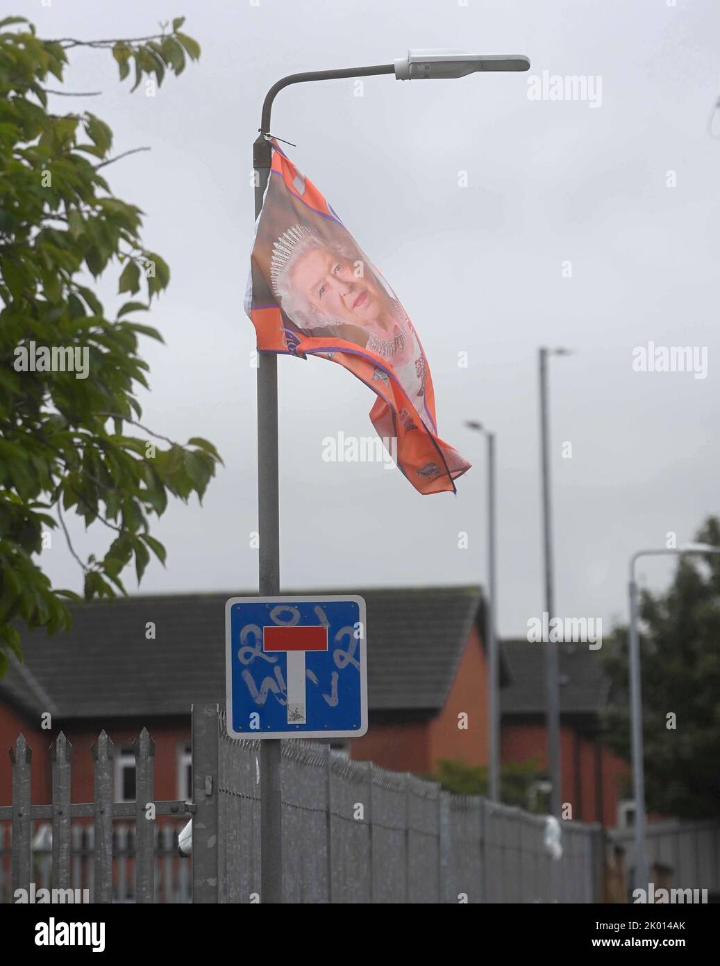 Una bandiera che mostra un'immagine della regina Elisabetta II è appesa su un lampione di Caledon Street, sulla Shankill Road a Belfast, dopo la sua morte di giovedì. Data immagine: Venerdì 9 settembre 2022. Foto Stock