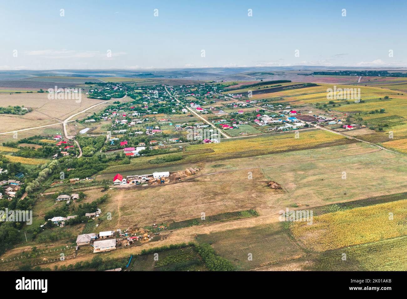 Paesaggio rurale del villaggio con campi agricoli patchati gialli. Campi agricoli di grano in un'area rurale, in Europa Foto Stock