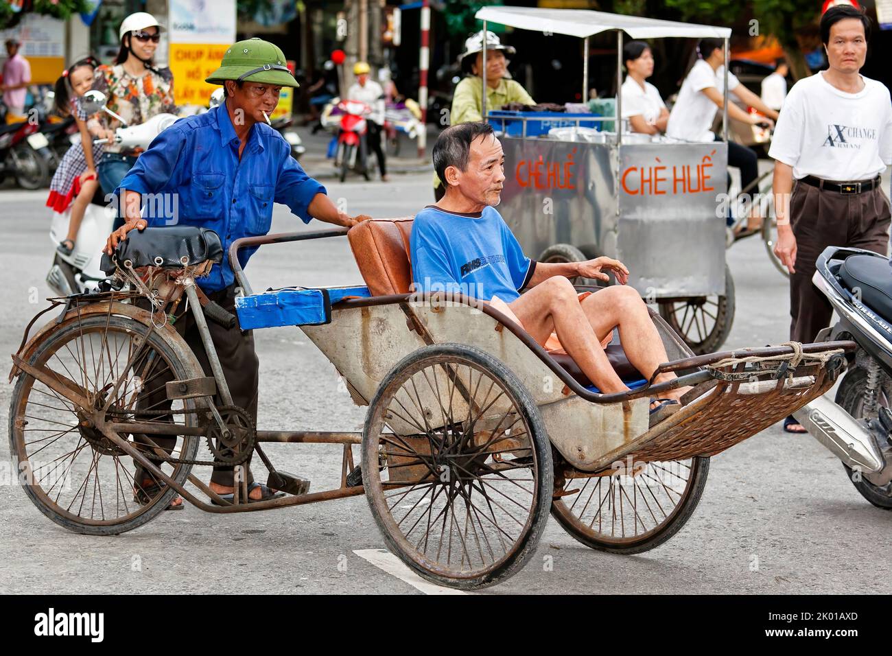 Bicicletta vietnamita risciò, pilota e passeggero nel traffico, Hai Phong, Vietnam Foto Stock