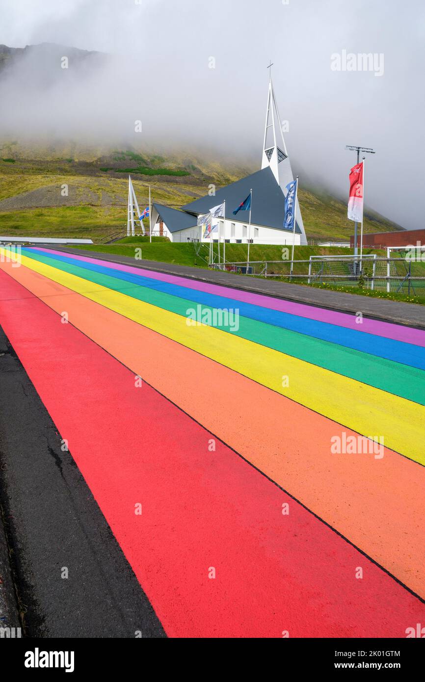 Una strada di colore arcobaleno che conduce all'Olafsvikurkirkja (chiesa), Olafsvik, Islanda Foto Stock
