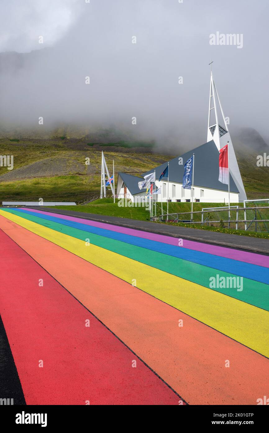 Una strada di colore arcobaleno che conduce all'Olafsvikurkirkja (chiesa), Olafsvik, Islanda Foto Stock