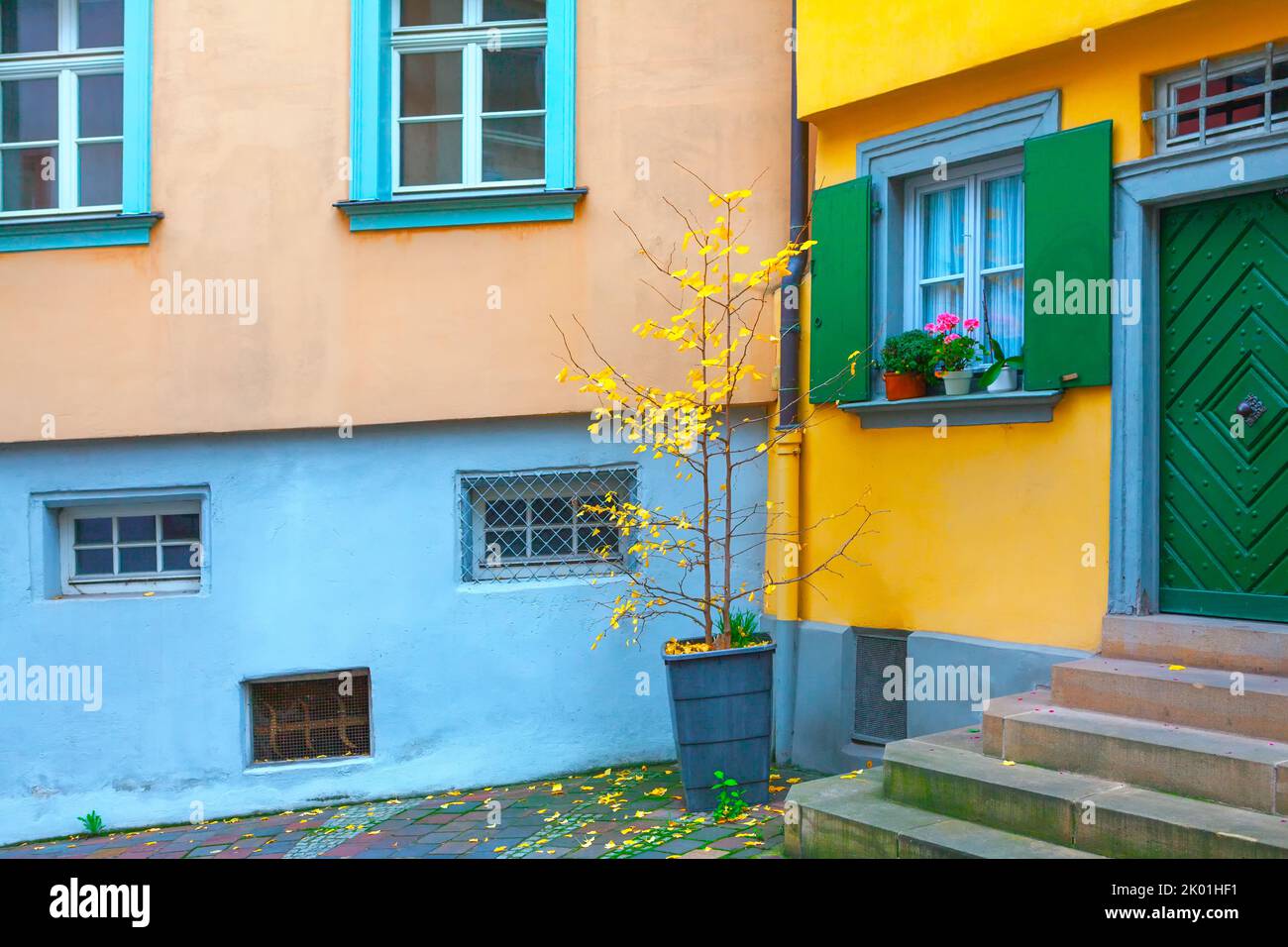 Cortile interno con foglie in autunno . Pareti colorate di case nella stagione autunnale Foto Stock
