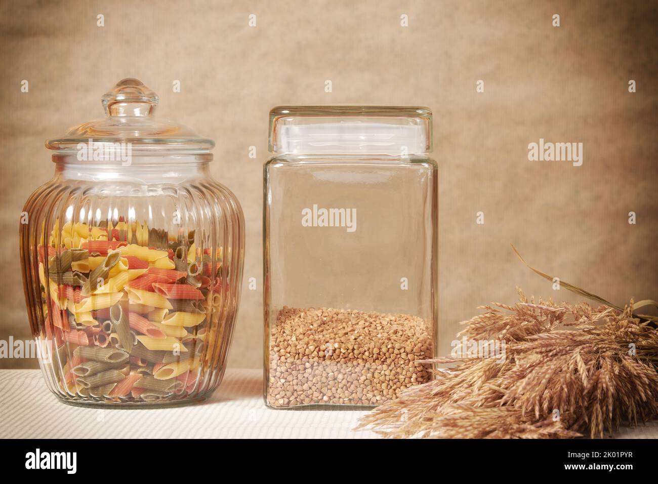 Grano saraceno, spighe di grano e pasta colorata su un tovagliolo sul tavolo. Cucina rurale tradizionale Foto Stock