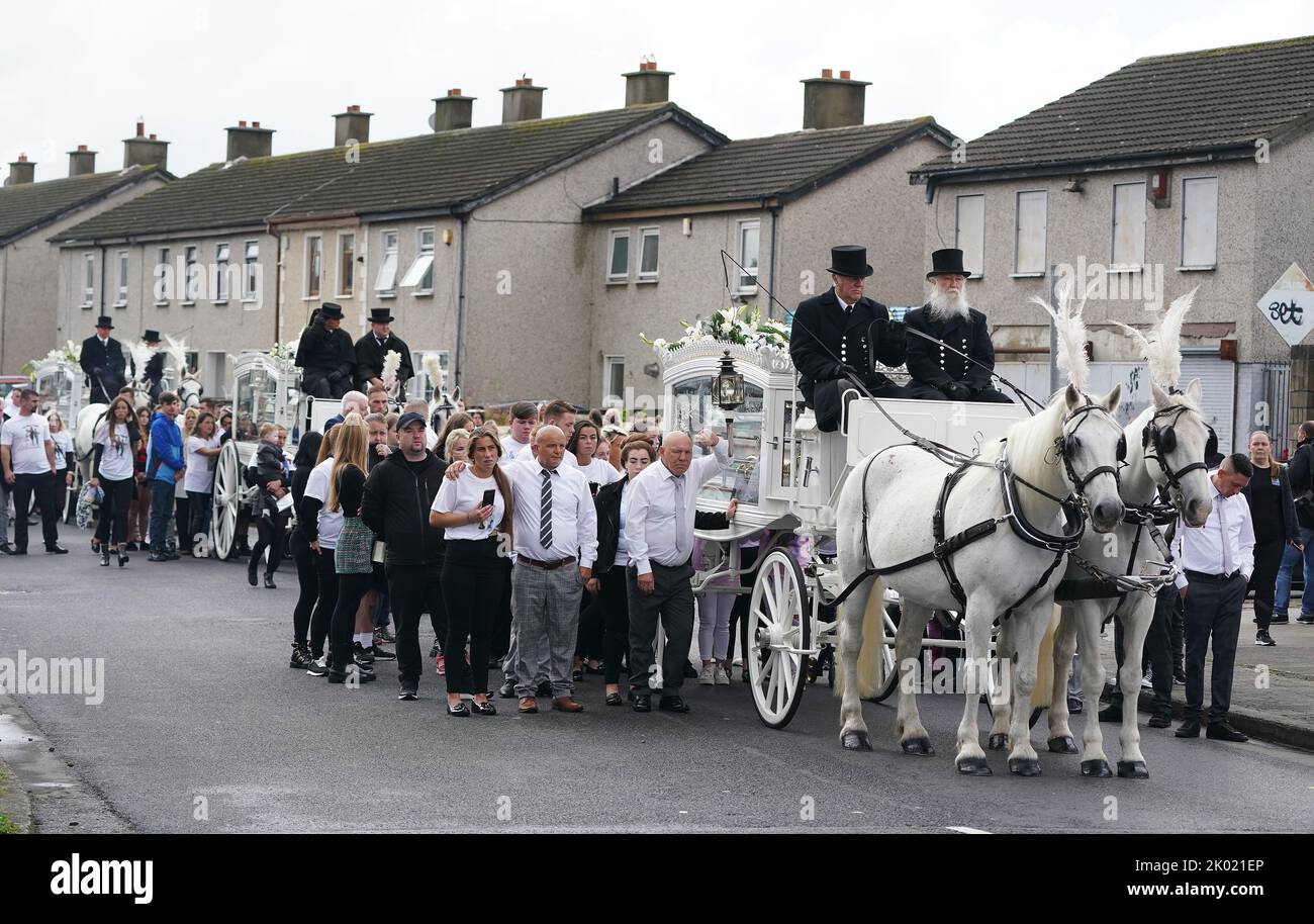 I pianori camminano dietro tre hearse trainate da cavalli che trasportano le bare di Lisa Cash, 18, e dei suoi fratelli gemelli di otto anni, Christy e Chelsea Cawley, dopo il loro servizio funerario alla St Aidan's Church, Brookfield, Tallaght. Data immagine: Venerdì 9 settembre 2022. Foto Stock