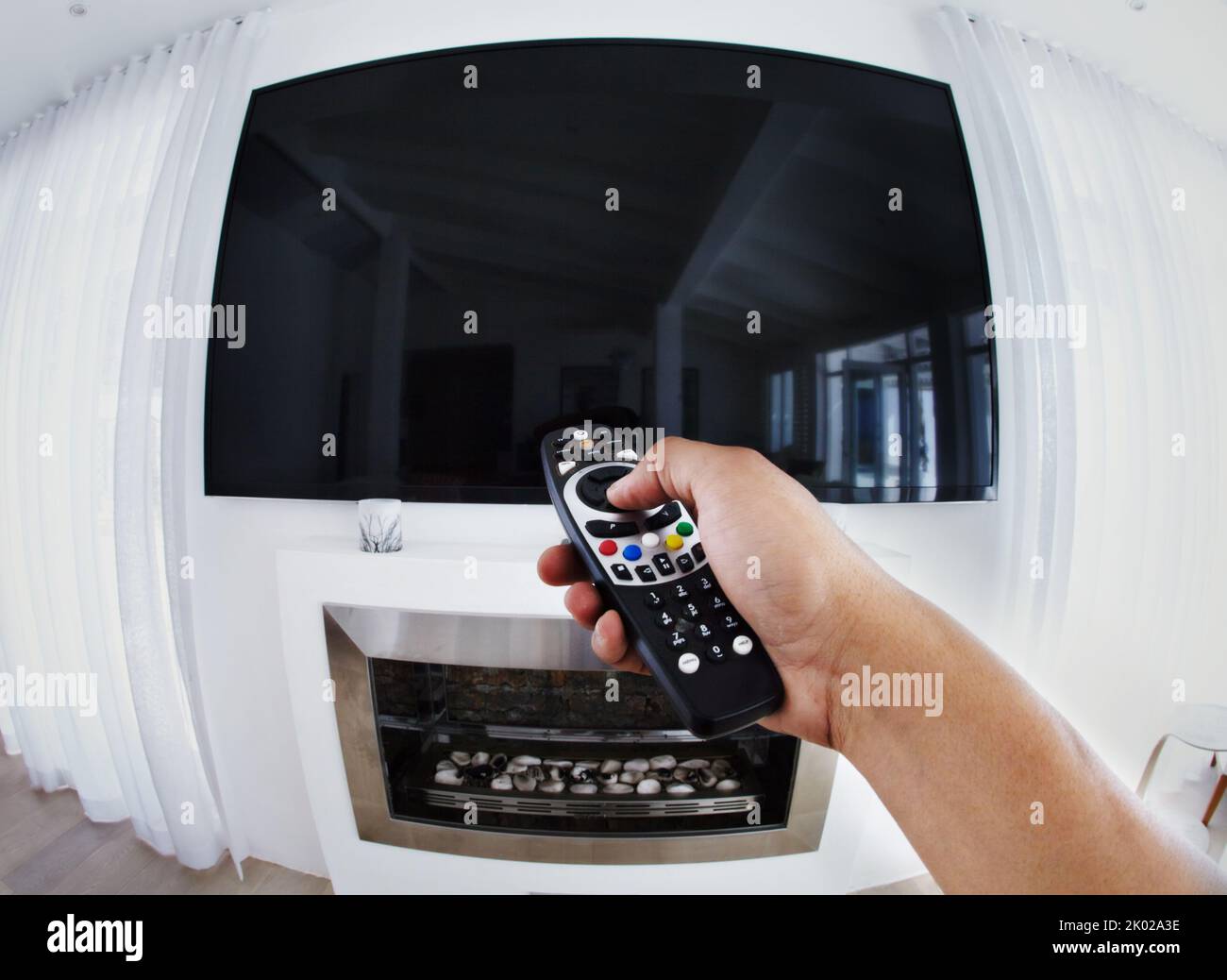 Preparati a divertirti. Ripresa POV di una persona che punta un telecomando a un televisore a schermo piatto. Foto Stock