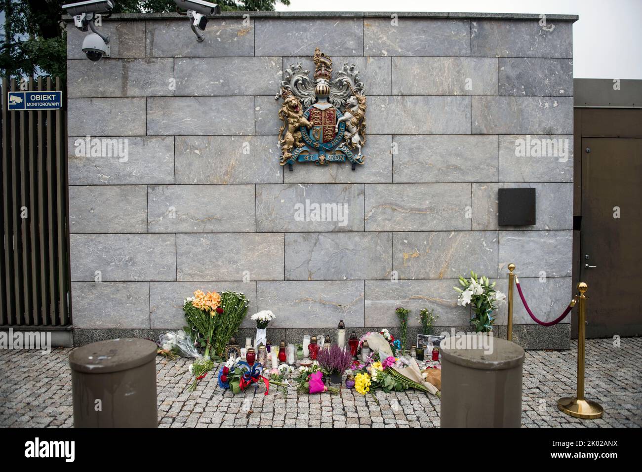 Varsavia, Polonia. 09th Set, 2022. Il muro dell'Ambasciata britannica Varsavia visto con fiori lasciati sotto lo stemma britannico. Dopo l'annuncio della morte di sua Maestà la Regina Elisabetta II, dalla mattina i cittadini di Varsavia lasciano fiori e candele per rendere omaggio a sua Maestà presso l'Ambasciata britannica di Varsavia. Credit: SOPA Images Limited/Alamy Live News Foto Stock