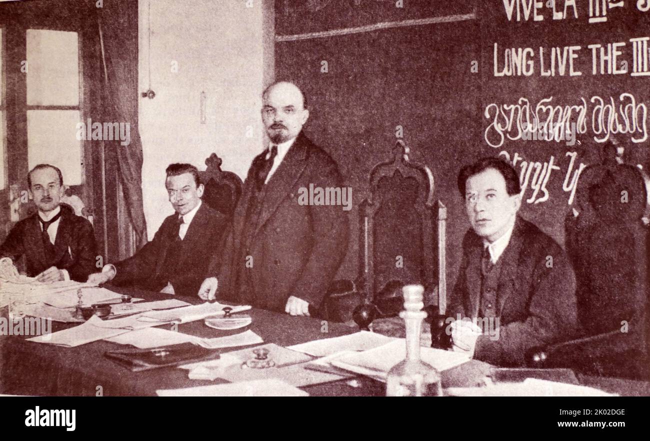 V.I. Lenin nel Presidium del 1st° Congresso dell'Internazionale Comunista. Seduti da sinistra a destra: G. Klinger (RSFSR), G. Eberlein (Germania), F. Platten (Svizzera). Mosca. Cremlino. Marzo 1919. Foto Stock