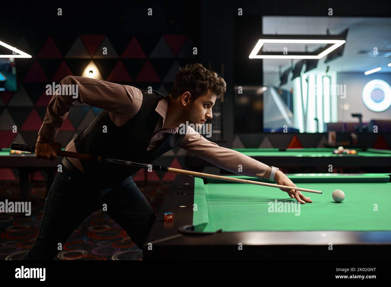Ritratto di giovane uomo puntato con stecca da biliardo Foto Stock
