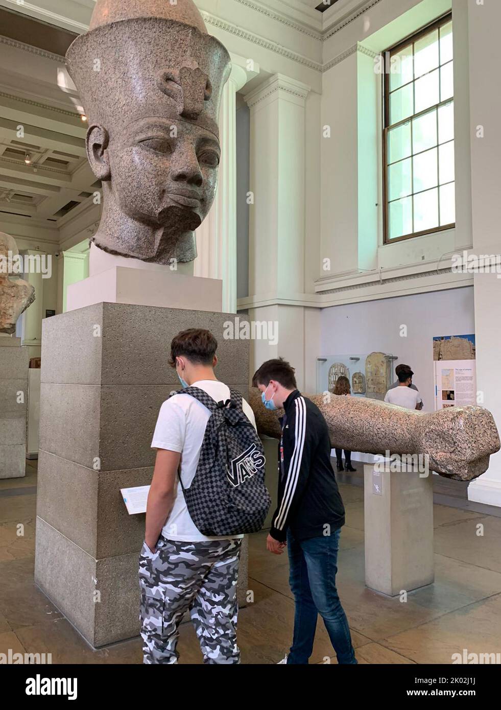 Due giovani studenti studiano una statua colossale egiziana del re Ramses II, al British Museum durante la pandemia del virus Corona del Covid-19. 19th settembre 2020 Foto Stock