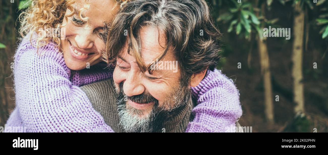 Primo piano ritratto di gioiosa coppia caucasica abbracciare un amante con la natura forestale sullo sfondo. Uomo e donna sorridenti e divertirsi insieme in attività ricreative all'aperto. Immagine intestazione banner Foto Stock