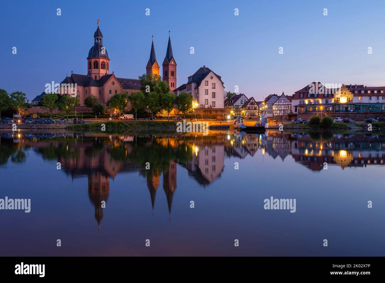 Germania, Hesse, Seligenstadt, Main, Mainufer, Benediktinerkloster, Einhard Basilika, illuminazione serale, skyline all'ora blu, lunga esposizione con il riflesso nel fiume Foto Stock