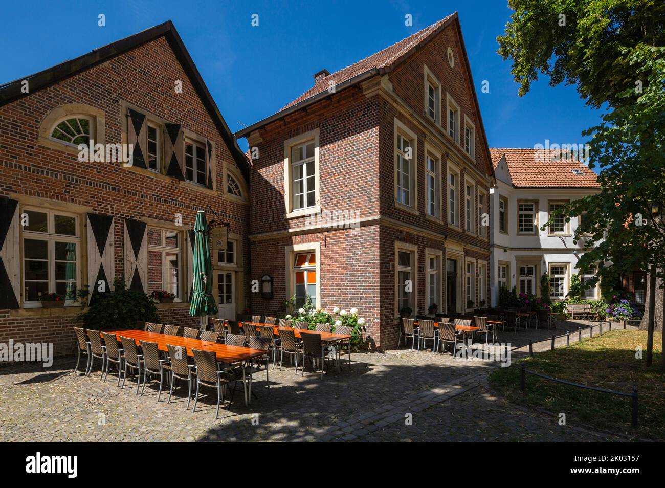 Germania, Billerbeck, Berkel, Baumberge, Muensterland, Westfalia, Renania settentrionale-Vestfalia, case a Johanniskirchplatz, case cittadine, case residenziali, edifici in mattoni, ristorante, tavoli e sedie vuoti Foto Stock