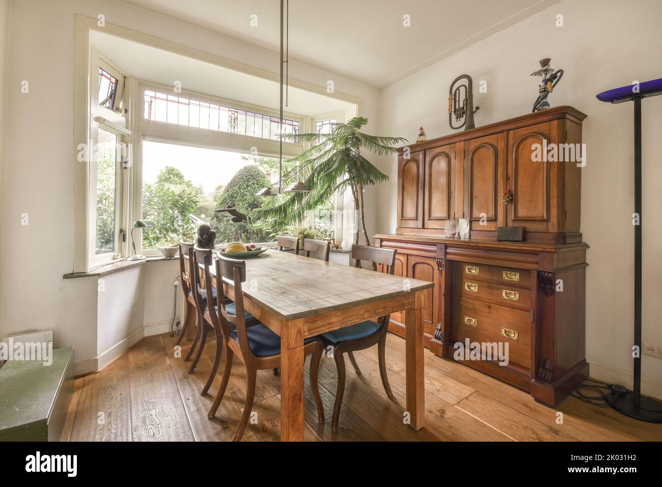 Semplice tavolo con sedie situato sotto un elegante lampadario vicino alle porte in un elegante sala da pranzo Foto Stock